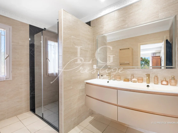 Salle de bain moderne avec douche et meuble vasque, éclairage naturel