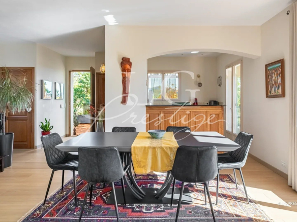 Intérieur d'une villa élégante avec salle à manger lumineuse et cuisine ouverte.