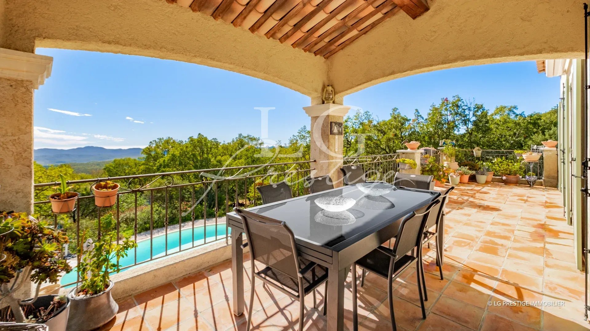 Terrasse de villa à Fayence Terrasse couverte avec table et chaises, vue sur jardin et piscine, environnement naturel à Fayence.