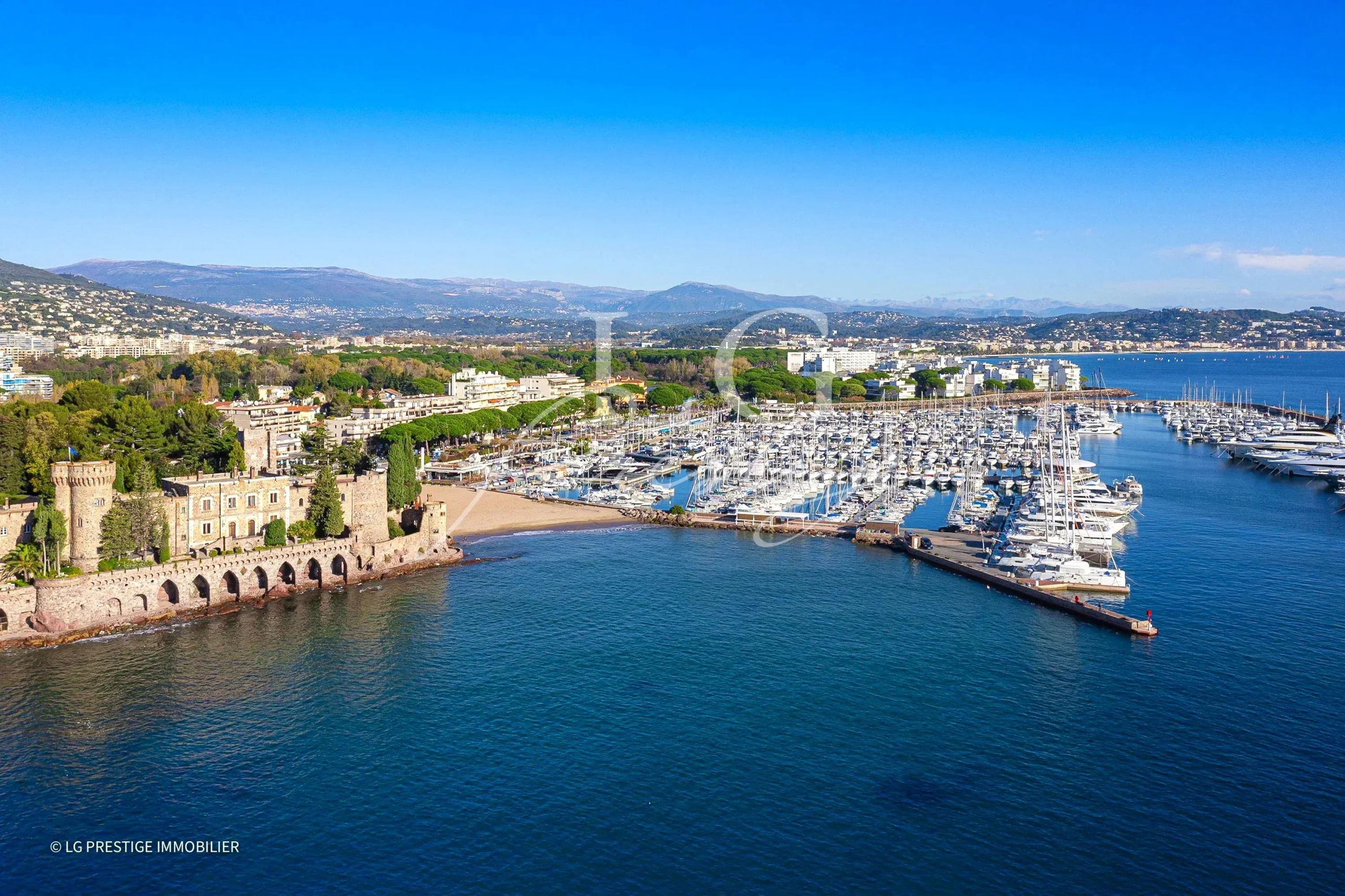 Vue aérienne de la marina et du littoral de Mandelieu-la-Napoule, avec des bateaux amarrés.