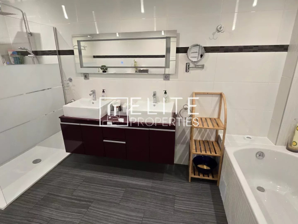 Modern bathroom with double sink vanity, glass shower, and white bathtub; wooden shelf beside tub.