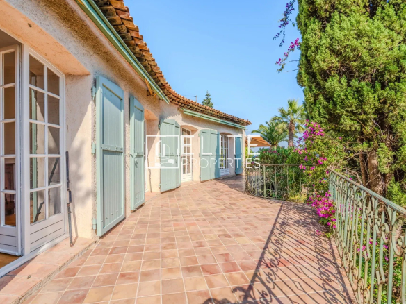 Terrasse d'une maison avec vue mer à Mandelieu-la-Napoule, entourée de verdure.