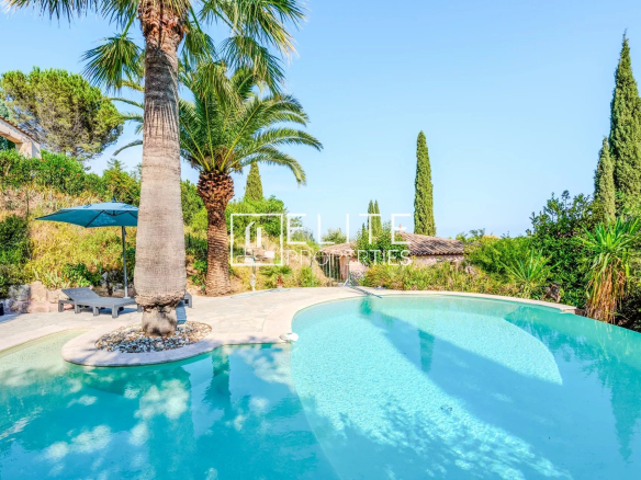 Piscine entourée de verdure dans une maison de charme à Mandelieu-la-Napoule.