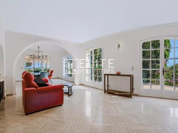 Intérieur d'une maison de charme avec vue mer, salon lumineux et mobilier élégant.
