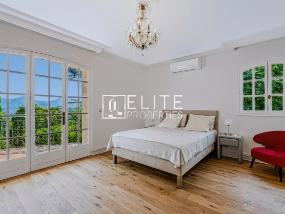 Chambre lumineuse avec vue sur la mer, lit double et décoration élégante.