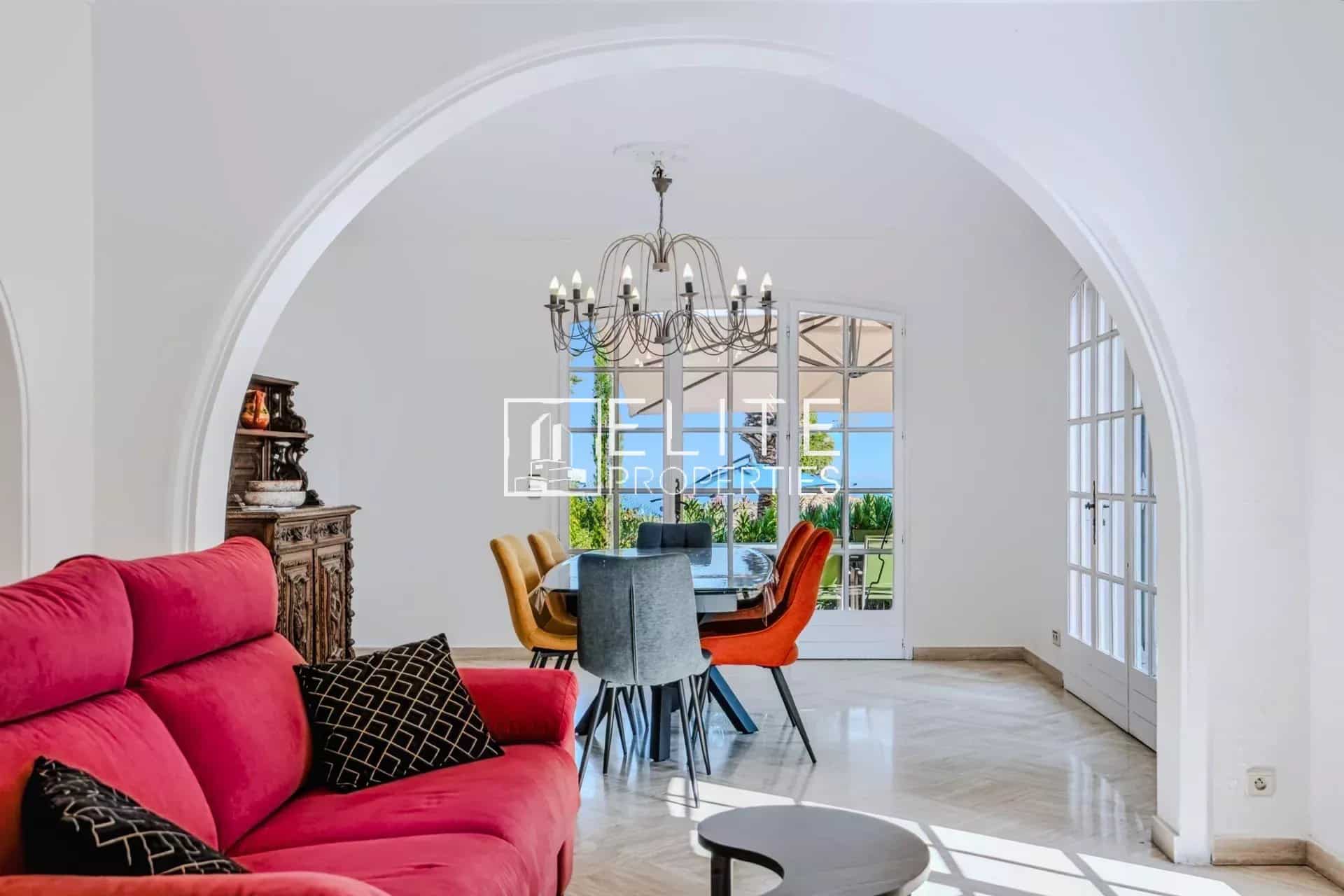 Intérieur d’une maison avec vue mer Intérieur d'une maison avec un salon rouge et une salle à manger lumineuse, vue sur la mer à Mandelieu-la-Napoule.