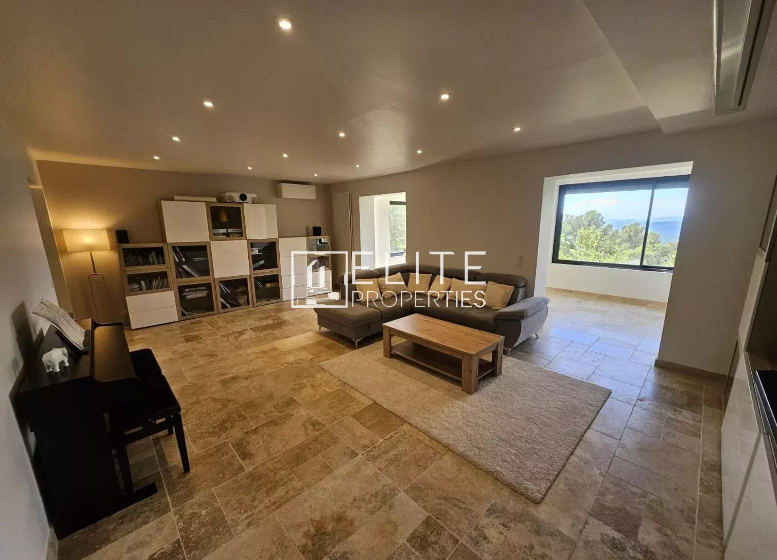 Interior of a spacious house with a bright living room and a view of nature.