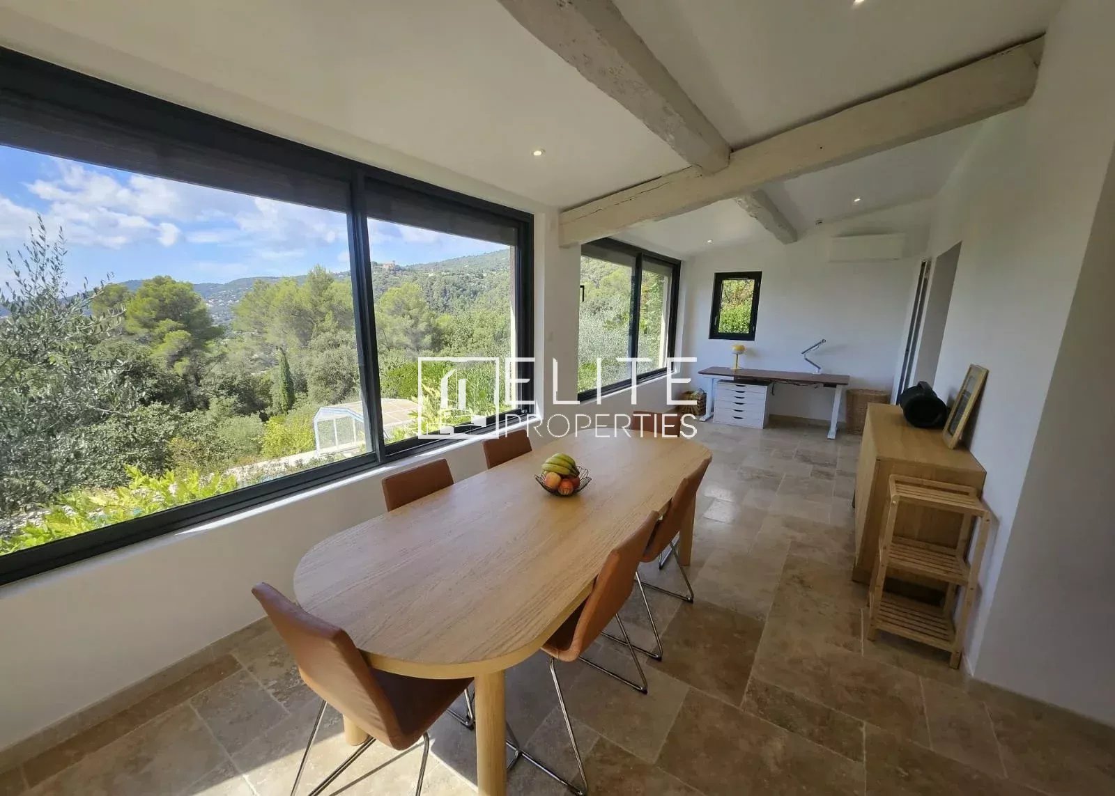 Interior of a bright dining room with a view of nature, wooden table and modern chairs.
