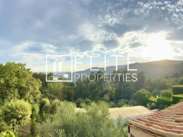 Panoramic view of nature and the village of Cabris, with a cloudy sky.