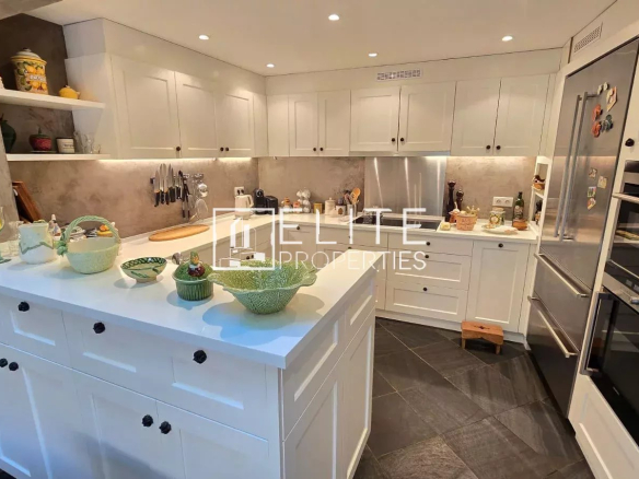 Modern kitchen with central island and integrated appliances in a house in Mouans-Sartoux.