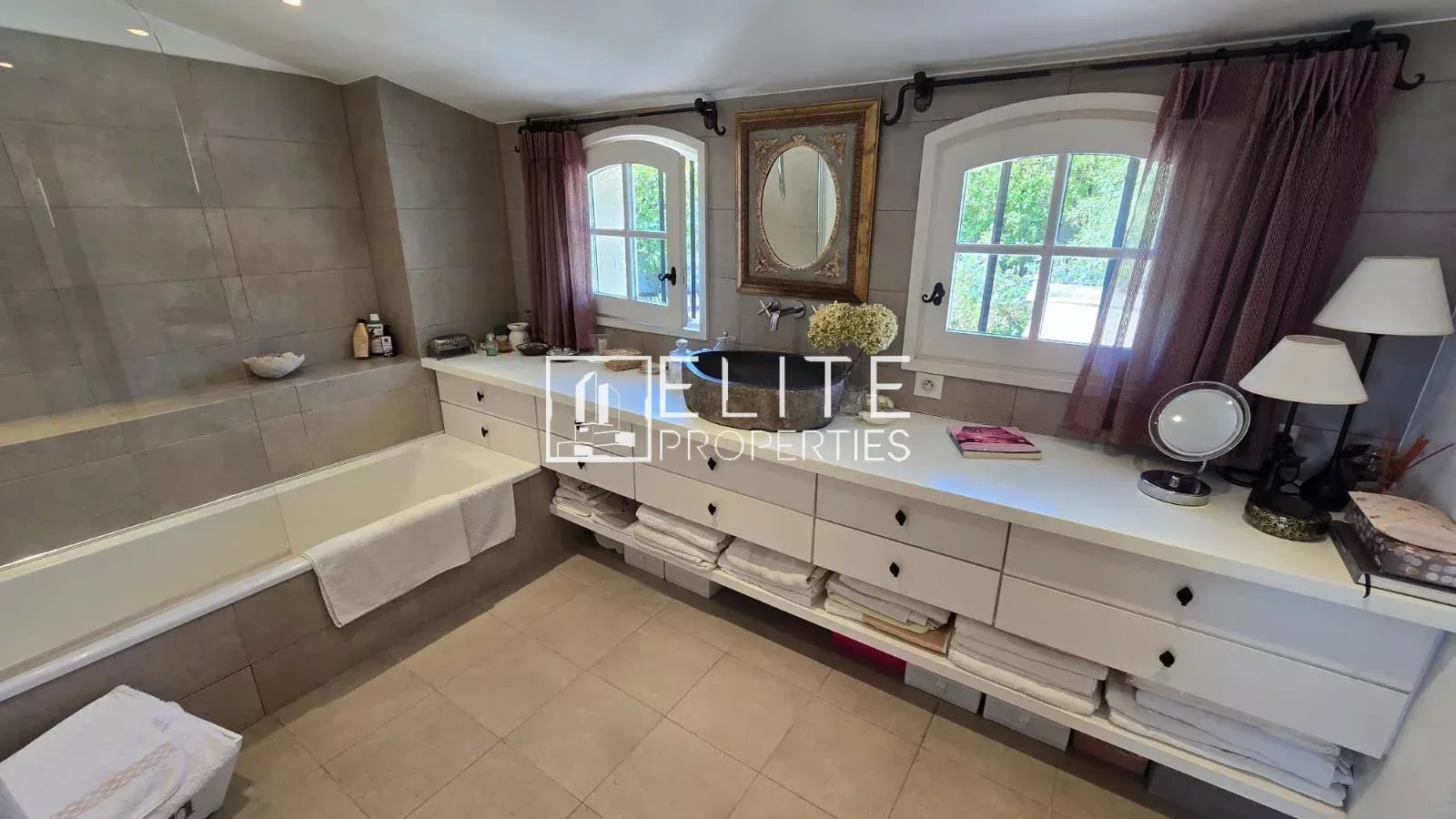 Bathroom in the house in Mouans-Sartoux Modern bathroom with bathtub, storage unit and small-paned windows.