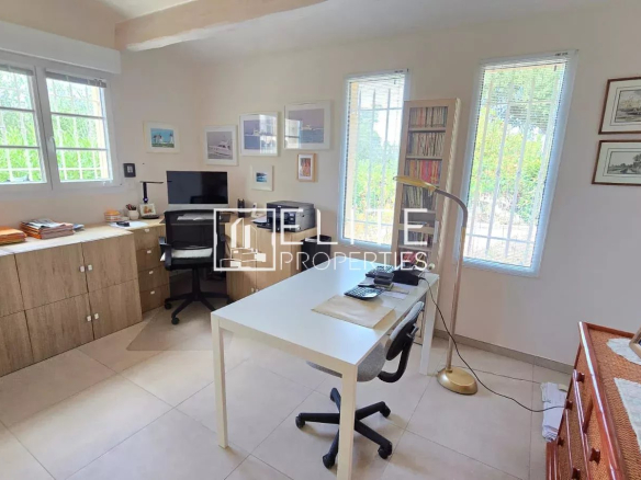 Bureau lumineux dans une maison de plain-pied à Tanneron, avec mobilier moderne et fenêtres offrant une vue sur l'extérieur.