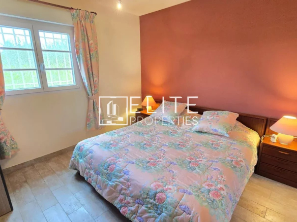 Chambre d'une maison de plain-pied à Tanneron, avec lit, table de nuit et fenêtre.
