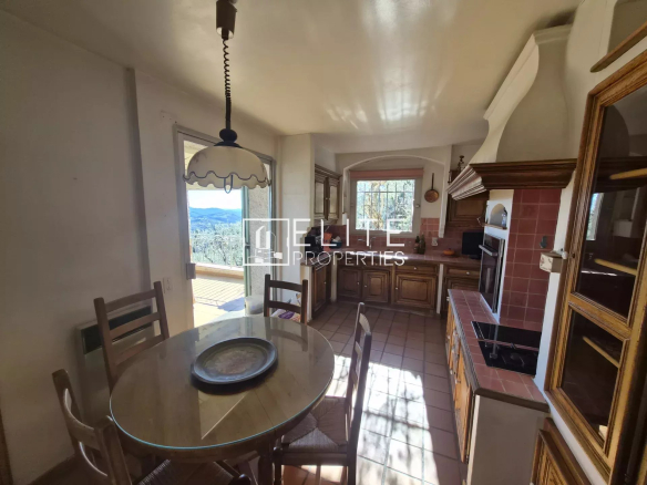 Cuisine d'une villa à Spéracèdes avec vue panoramique, table ronde et éléments en bois.