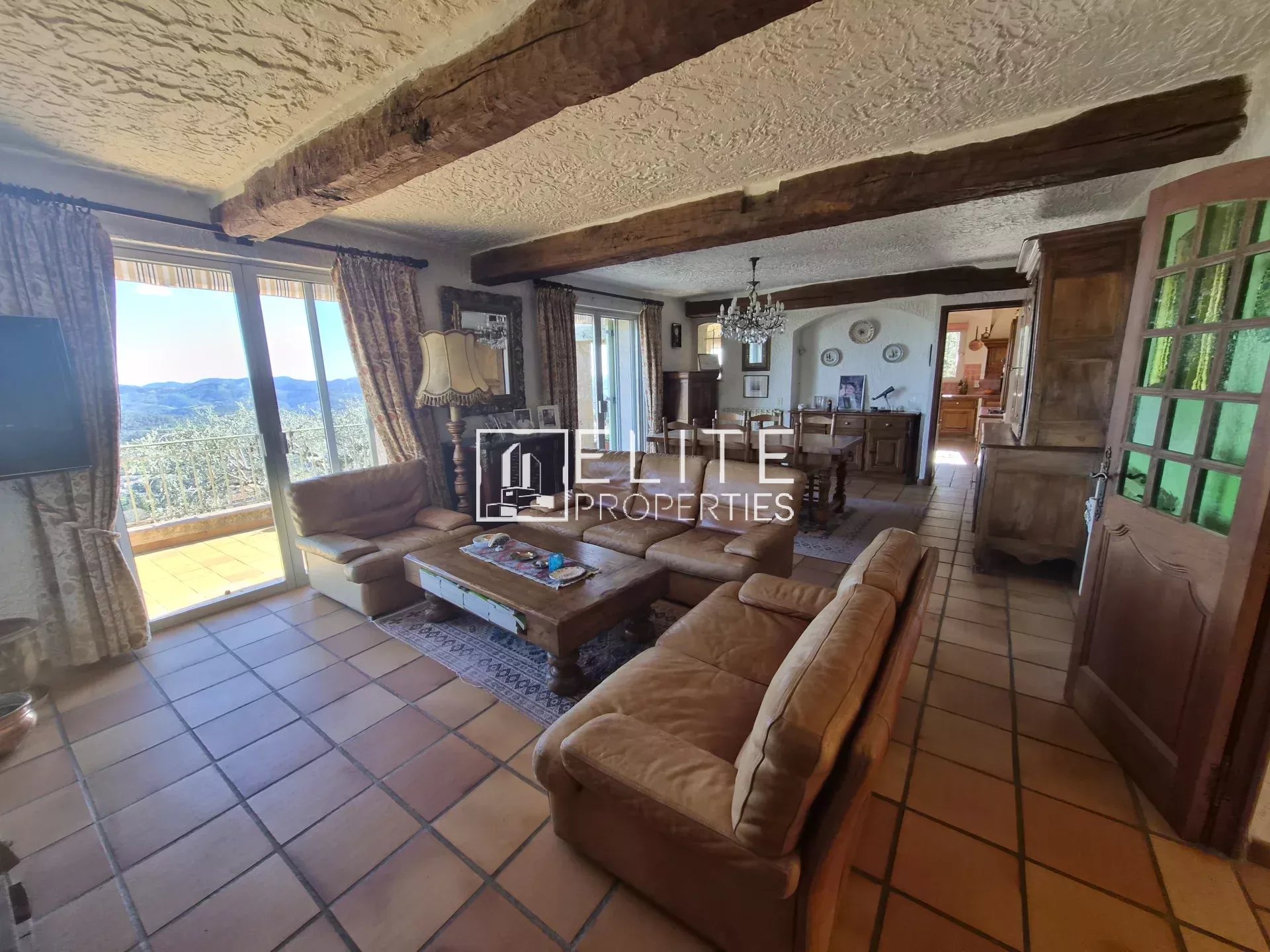 Intérieur d'une villa à Spéracèdes avec un salon spacieux et des meubles en bois.