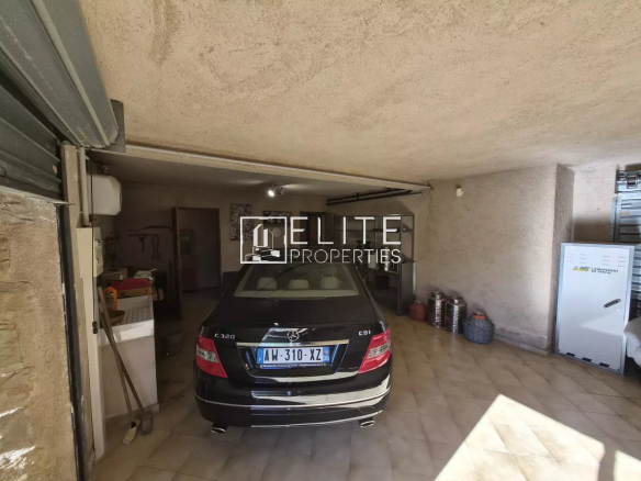 Intérieur d'un garage avec une voiture noire et des équipements visibles.