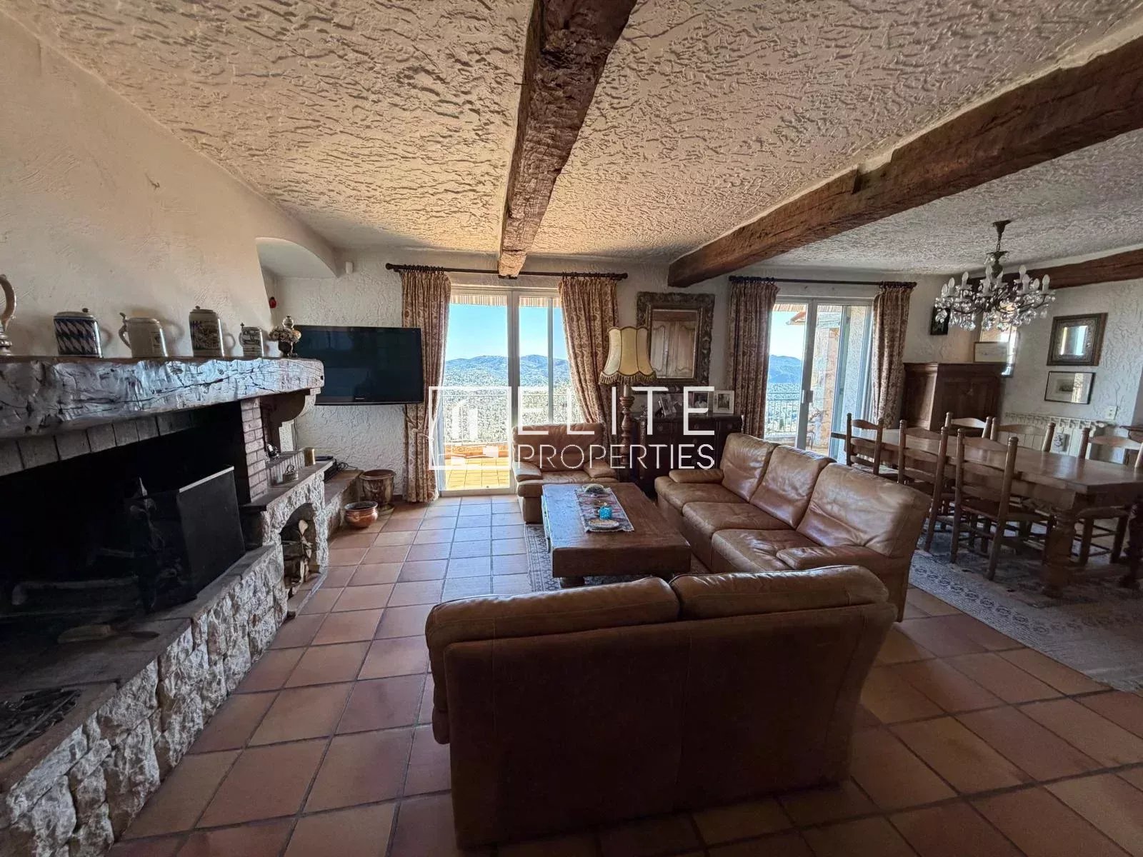 Intérieur d'une villa à Spéracèdes avec salon, cheminée et vue panoramique.