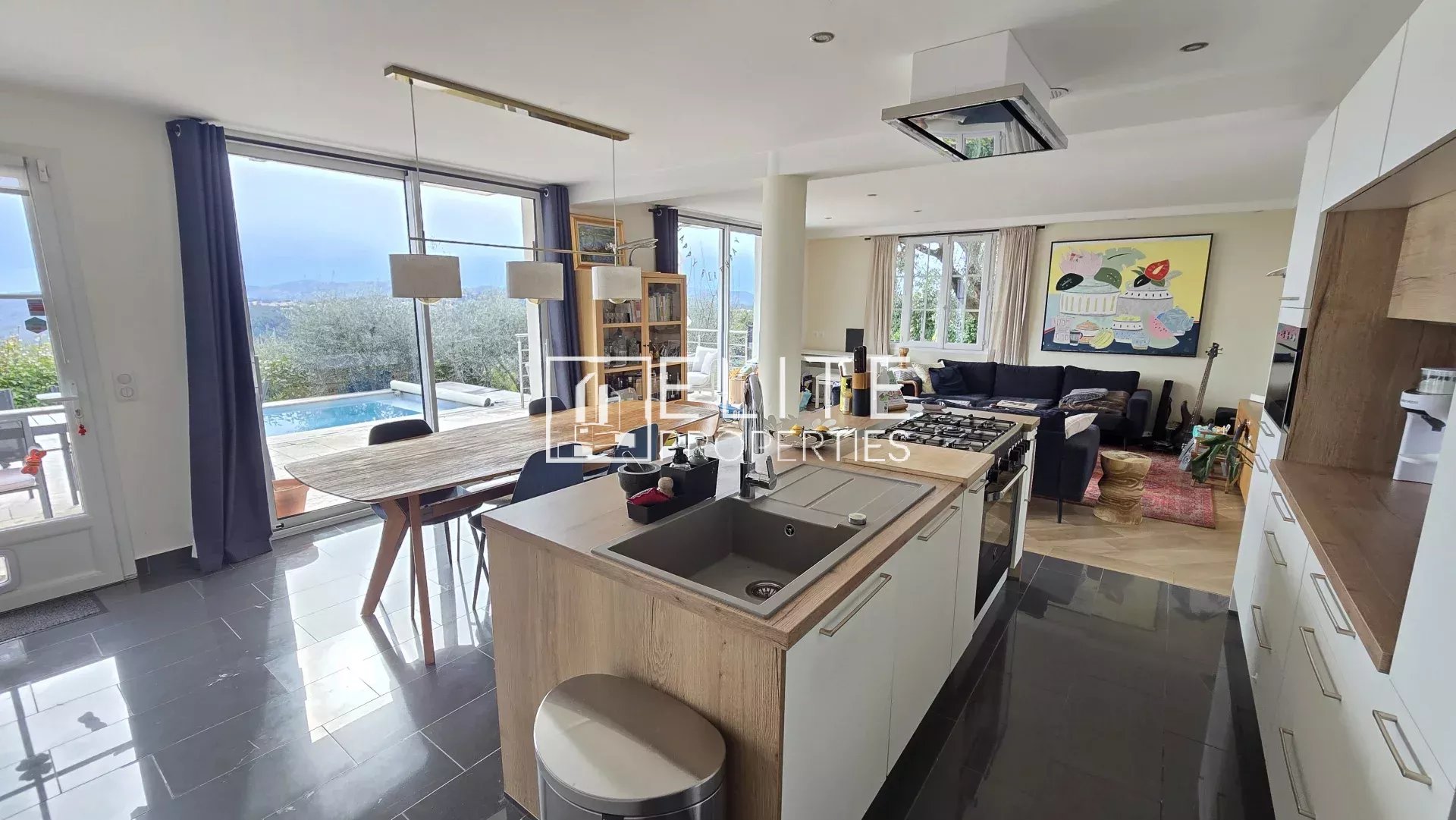 Intérieur d’une maison à Cabris Intérieur d'une maison moderne avec cuisine ouverte et vue sur la piscine.