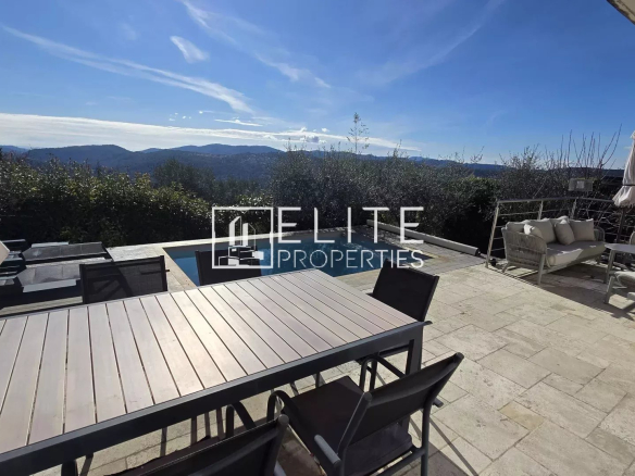 Terrasse avec table et chaises, piscine et vue panoramique sur les montagnes à Cabris