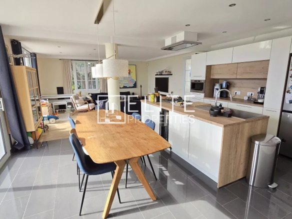 Intérieur d'une maison moderne avec cuisine américaine et salle à manger.