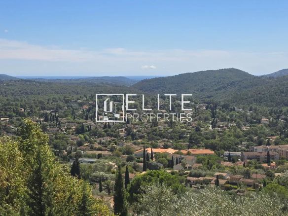 Vue panoramique sur la vallée et la mer depuis Cabris, avec des collines verdoyantes.