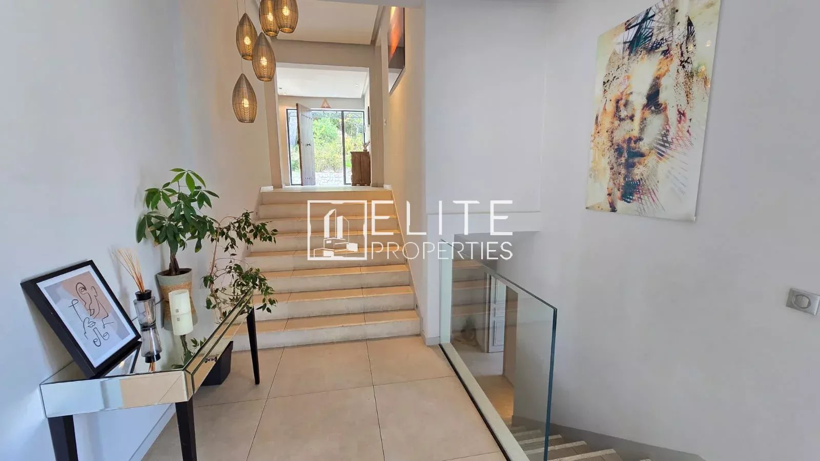 Intérieur d'une maison moderne avec un hall d'entrée lumineux et des escaliers.