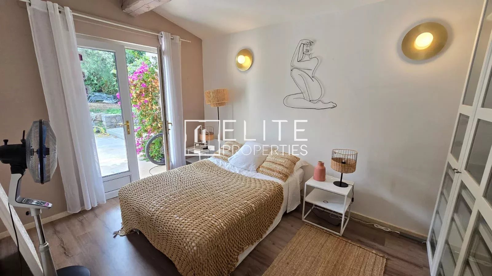 Chambre d'une maison avec lit, décoration simple et accès à l'extérieur.