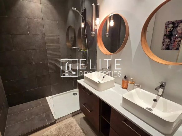 Salle de bain moderne avec douche, deux lavabos et miroirs ronds.