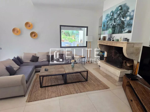 Intérieur d'une maison moderne avec salon, cheminée et accès à la piscine.