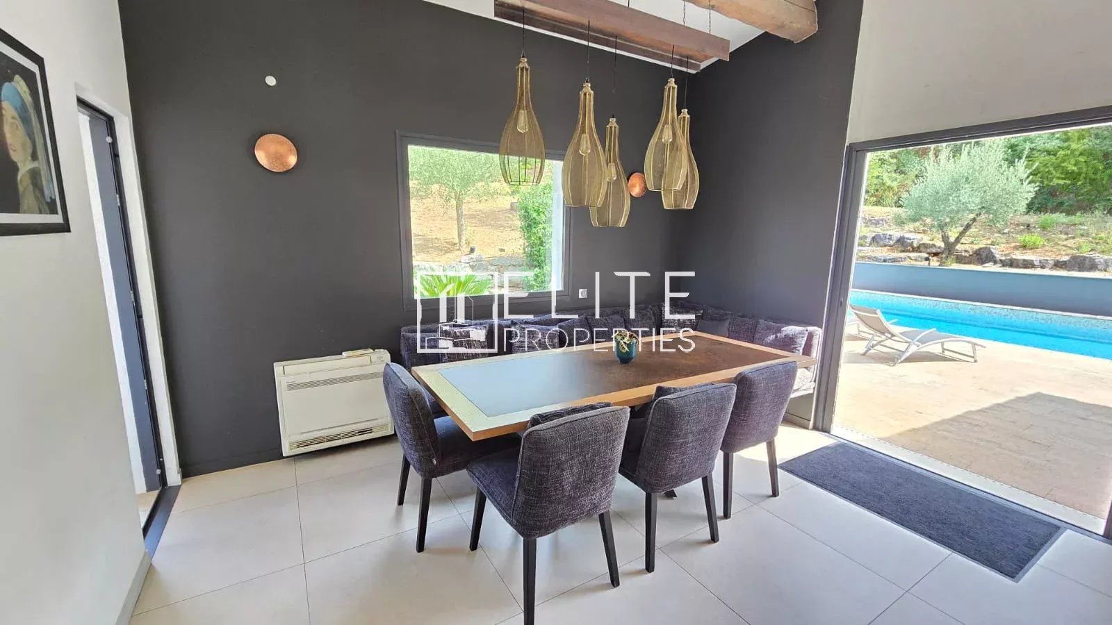 Salle à manger moderne avec table et chaises, vue sur piscine à Peymeinade.