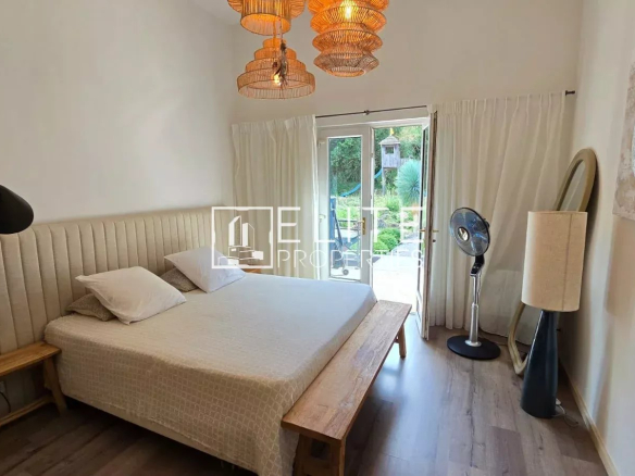 Chambre d'une maison à Peymeinade avec lit, fenêtres et décoration lumineuse.