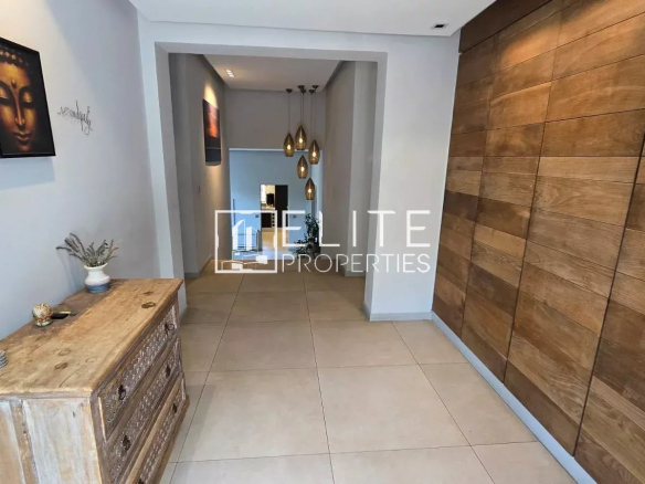 Intérieur d'une maison avec un hall d'entrée décoré et un meuble en bois.