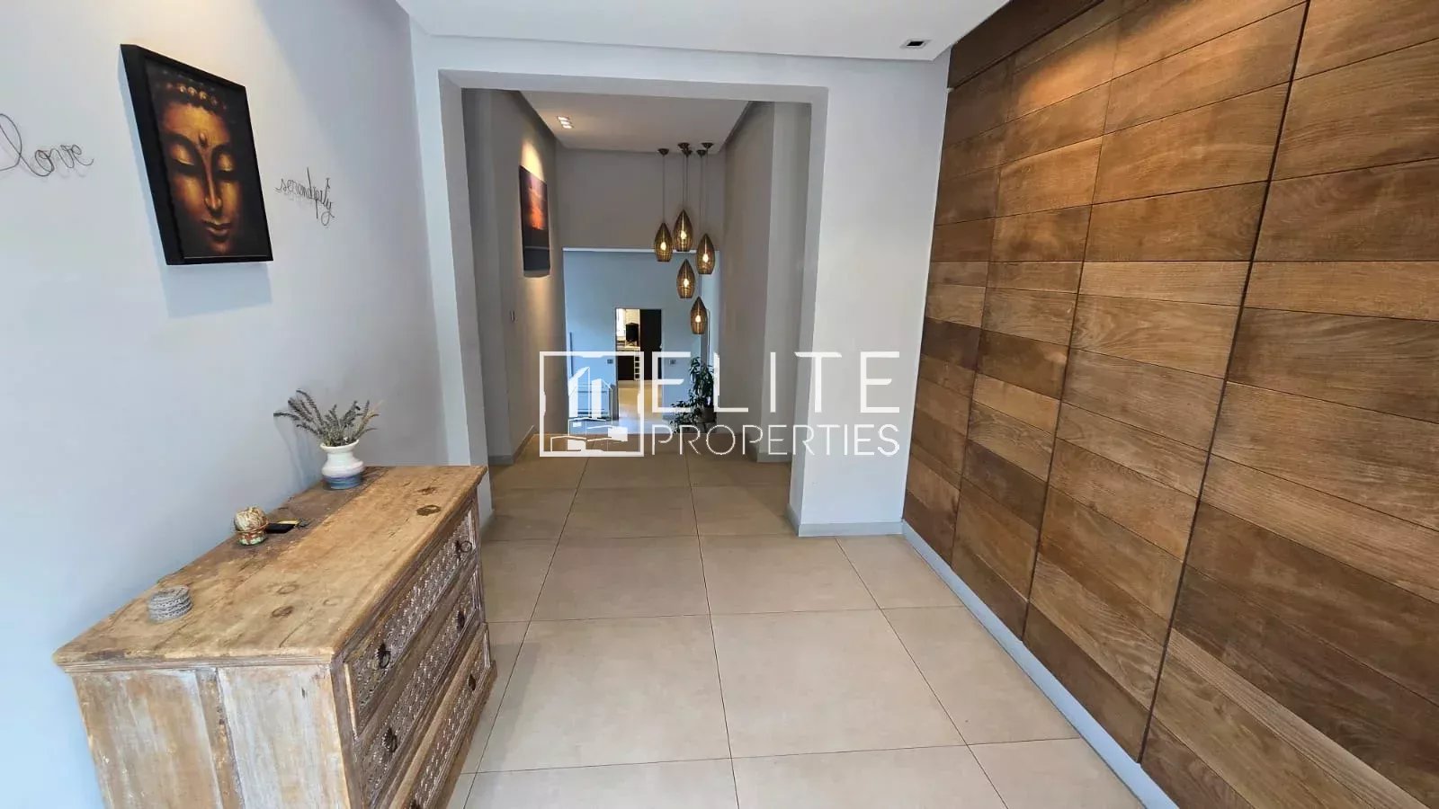 Intérieur d'une maison avec un hall d'entrée décoré et un meuble en bois.