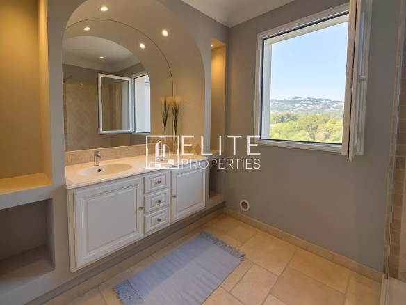 Modern bathroom with sink and window offering a view of nature.