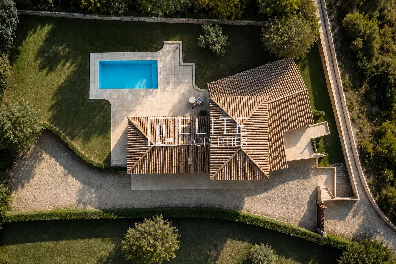 Aerial view of a villa with a swimming pool in Grasse, surrounded by greenery.
