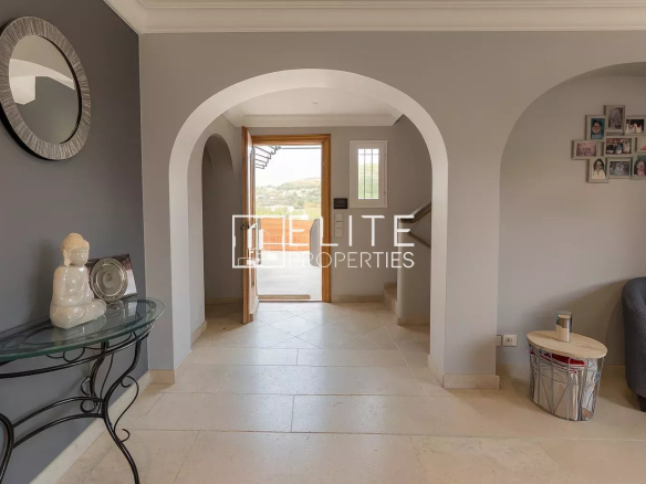 Interior of a modern villa with arches and grey walls.