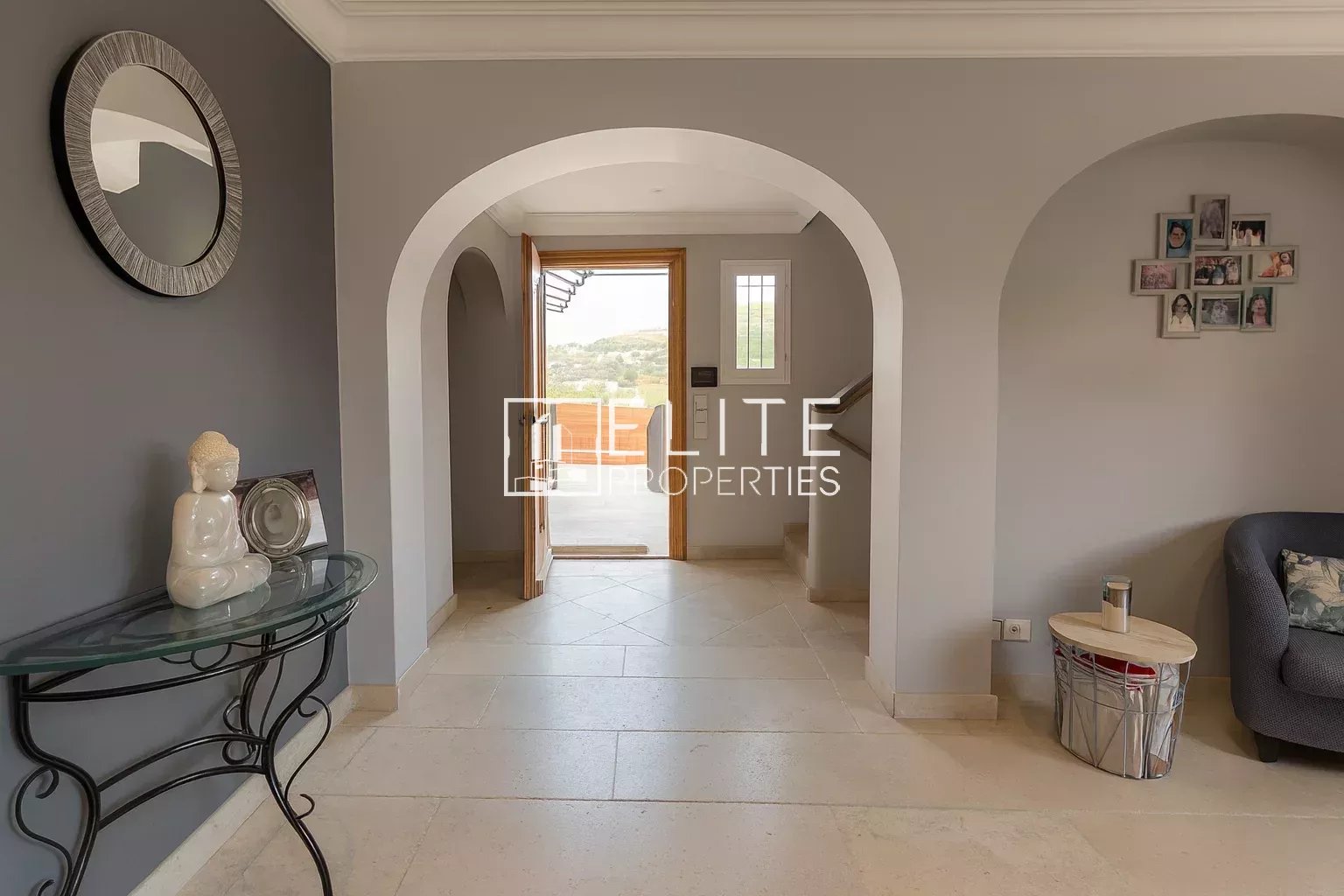 Interior of a modern villa with arches and grey walls.