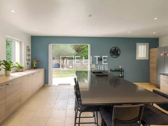 Interior of a modern villa with open kitchen and large dining table.