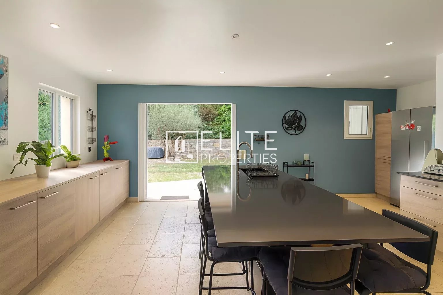 Interior of a modern villa with open kitchen and large dining table.