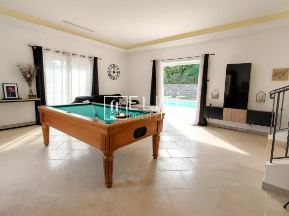 Interior of a villa with a pool table and access to the swimming pool.