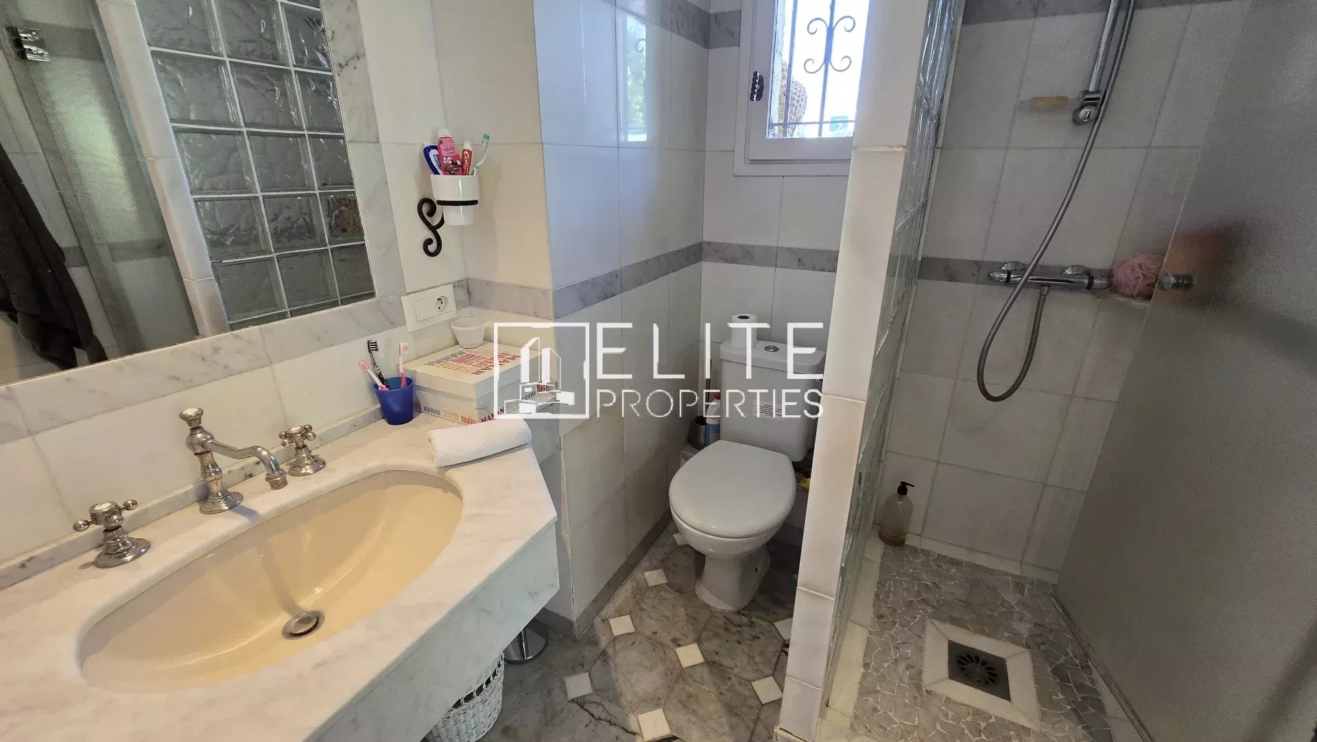 Salle de bain avec lavabo, douche et toilettes dans une maison à Mougins.