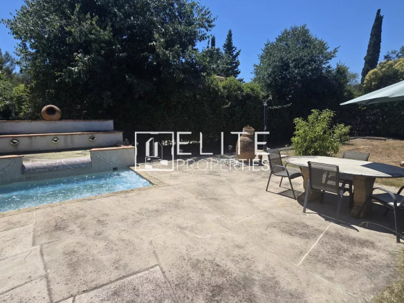 Terrasse avec piscine et table à manger dans un jardin à Mougins.