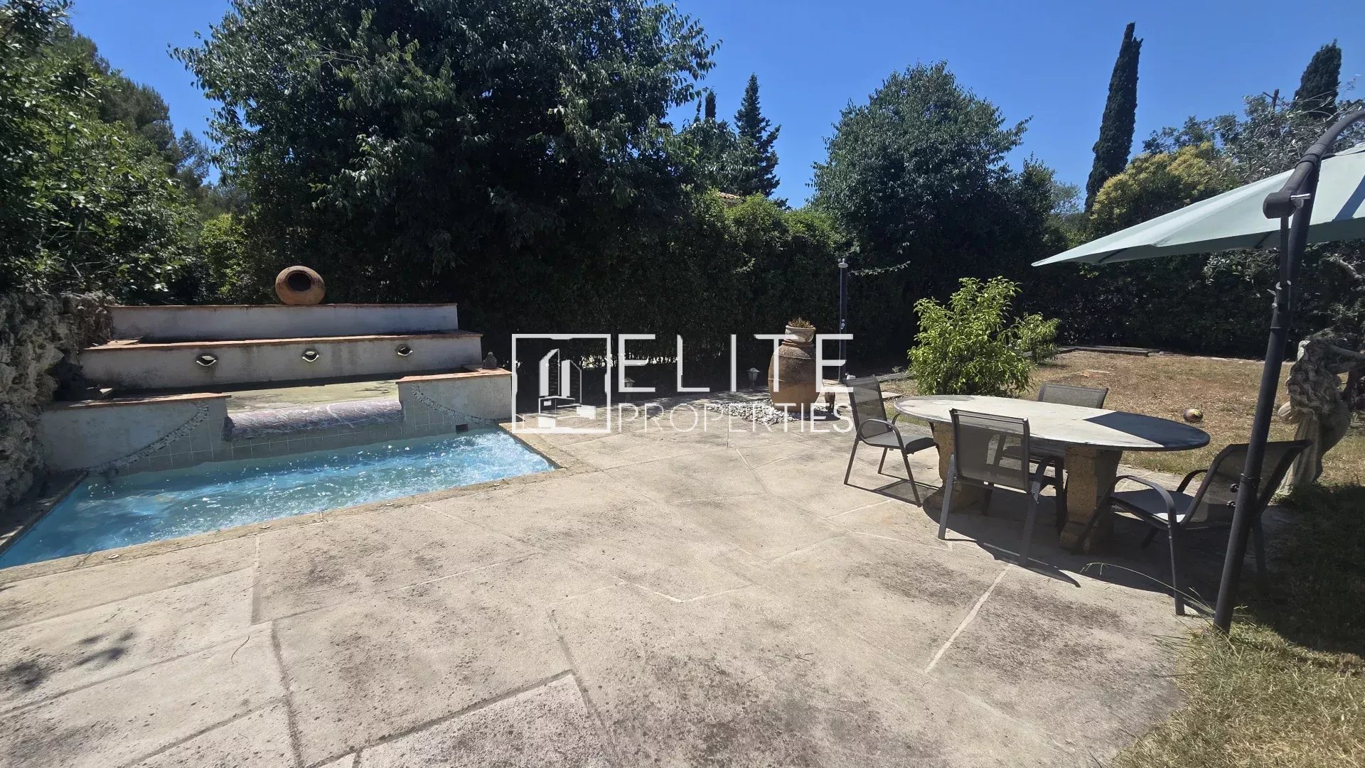 Terrasse avec piscine et table à manger dans un jardin à Mougins.