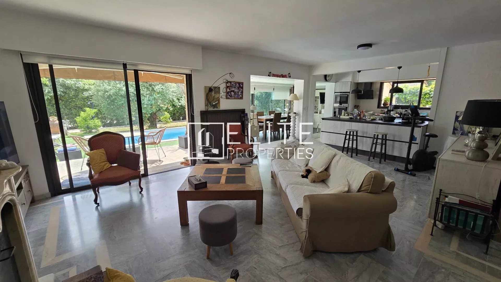 Intérieur d'une maison moderne avec salon spacieux et accès à la piscine.