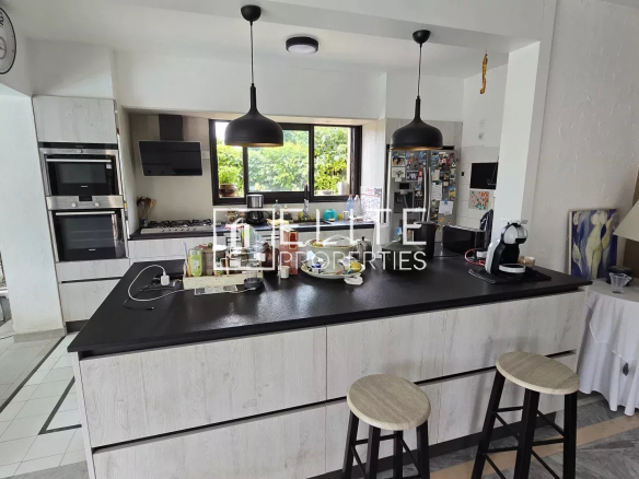 Cuisine moderne avec un îlot central et des équipements intégrés dans une maison à Mougins.