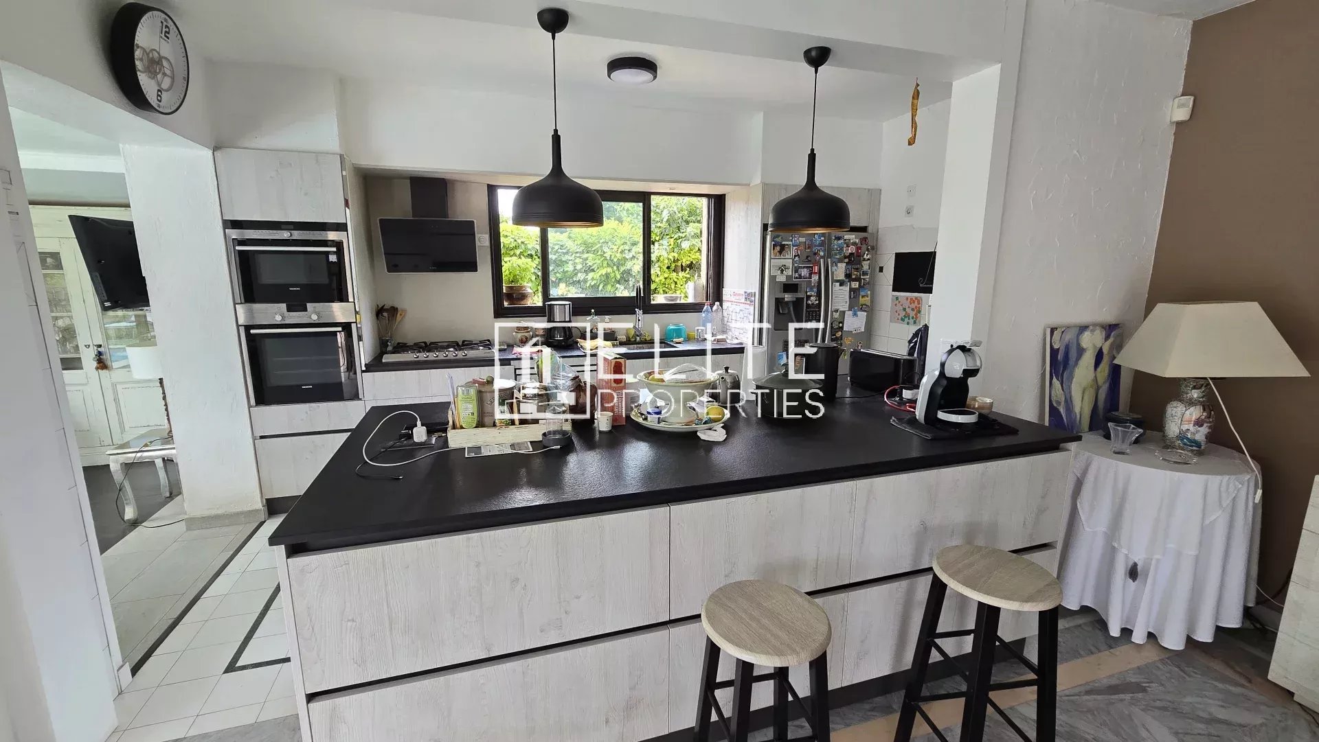 Cuisine moderne avec un îlot central et des équipements intégrés dans une maison à Mougins.
