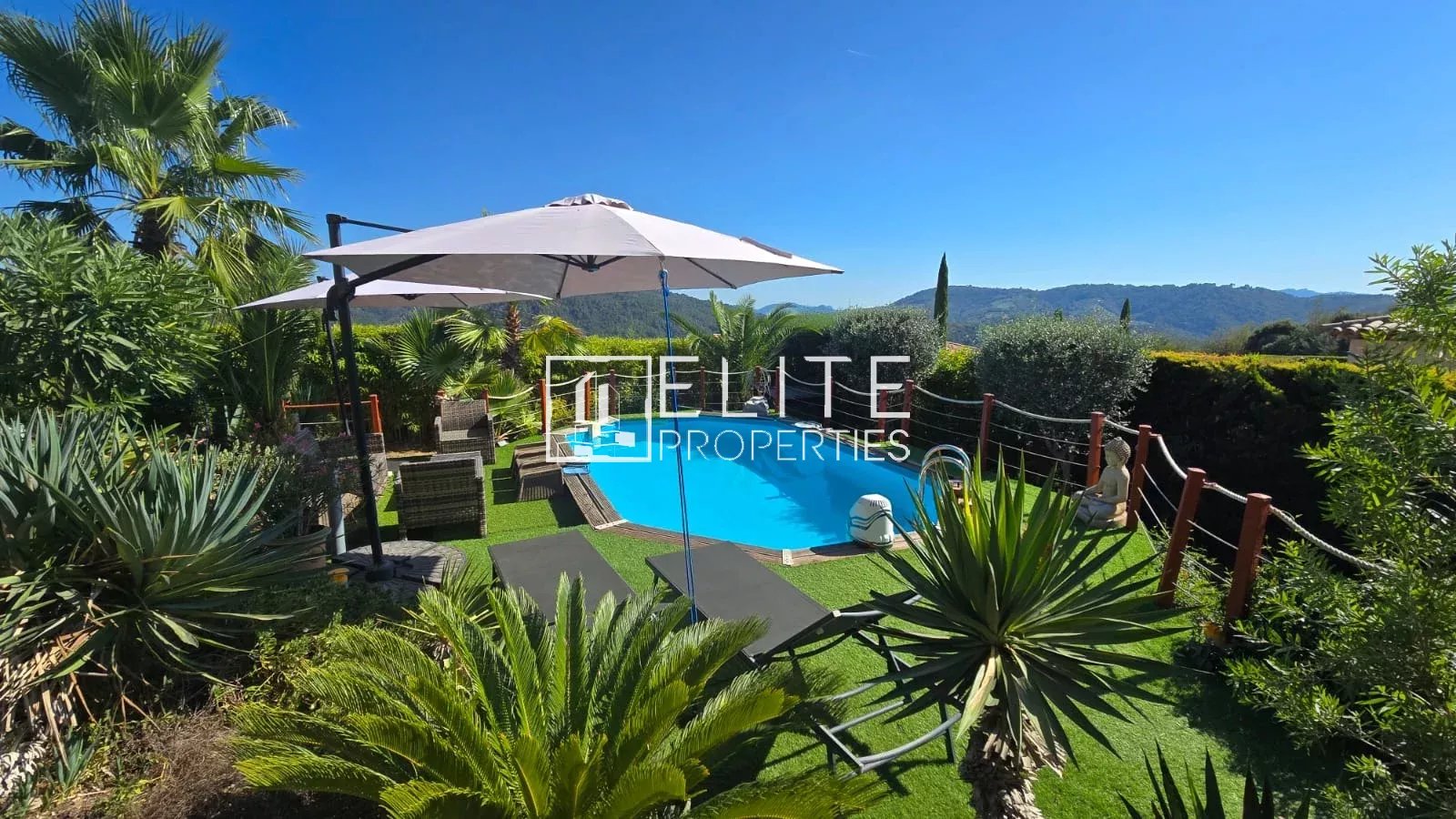Maison avec piscine à Tanneron Piscine entourée de végétation avec parasol à Tanneron.