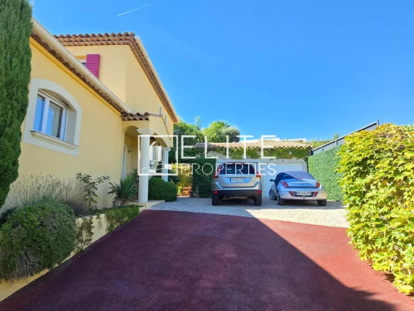 Entrée d'une maison à Tanneron avec deux voitures garées et un jardin verdoyant.