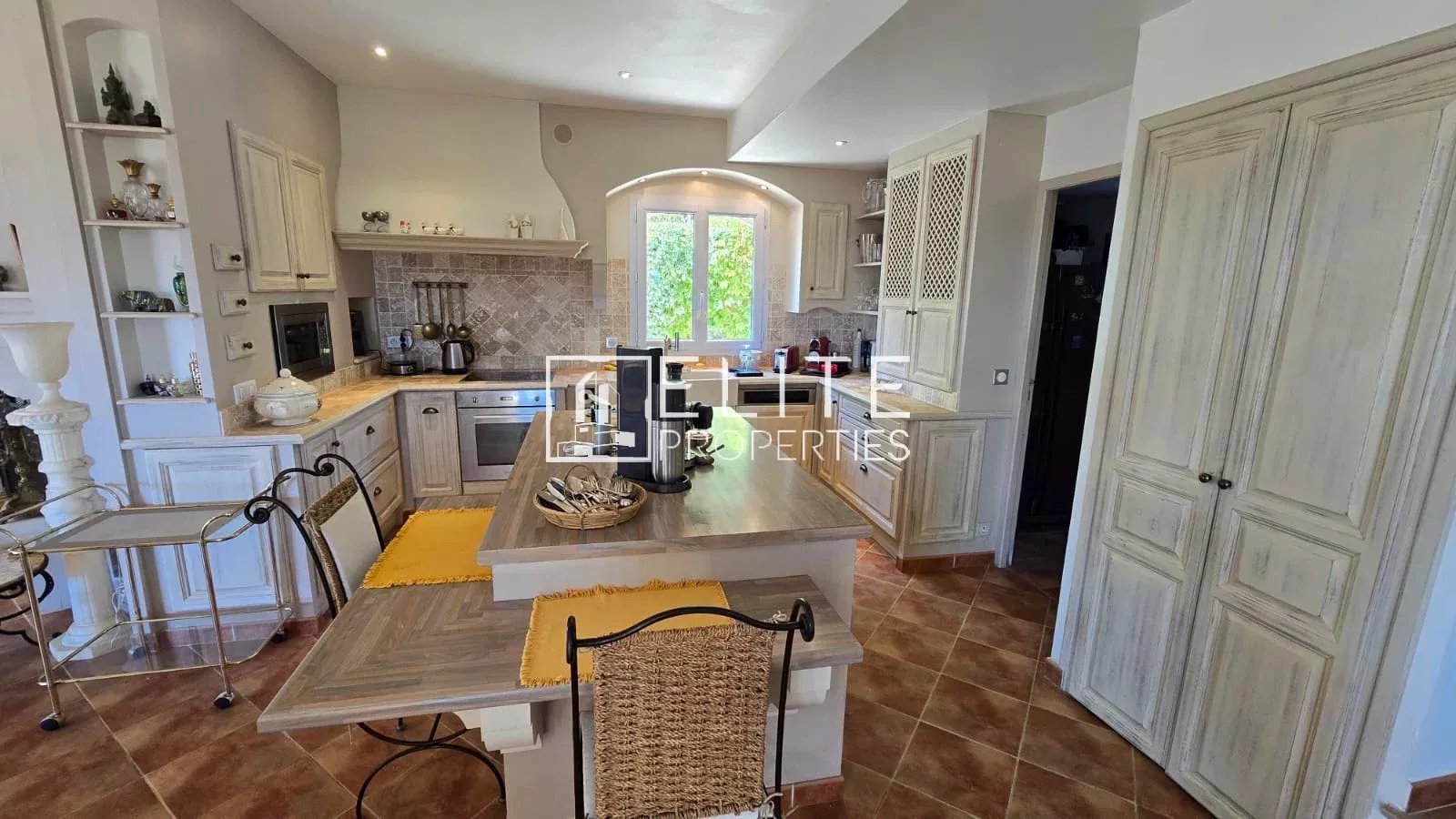 Cuisine moderne avec salle à manger Intérieur d'une cuisine moderne avec salle à manger, meubles en bois, et vue sur l'extérieur.