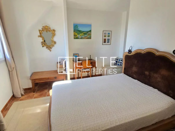 Chambre d'une maison à Tanneron avec lit et décoration simple.